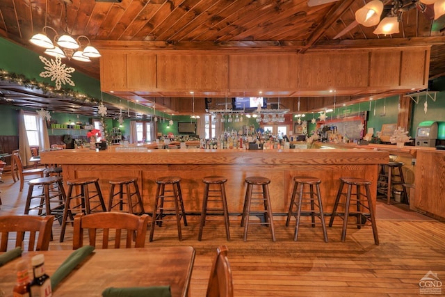 kitchen featuring a breakfast bar, light hardwood / wood-style flooring, beamed ceiling, and wooden ceiling