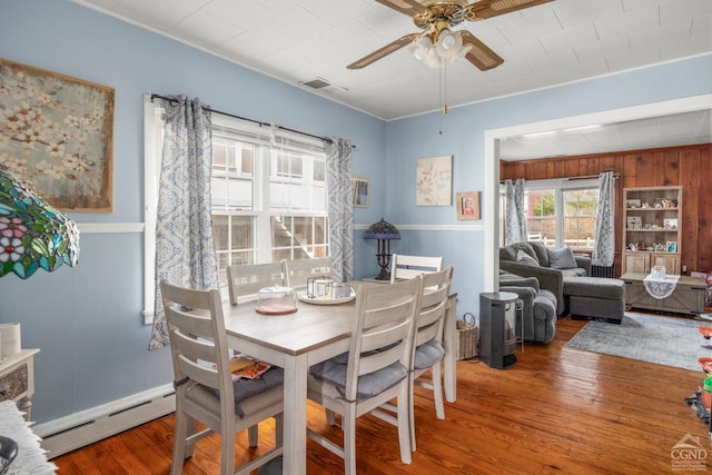 dining room with visible vents, a baseboard radiator, a ceiling fan, and wood finished floors