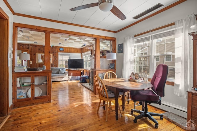 dining area featuring crown molding, ceiling fan, wood-type flooring, and visible vents