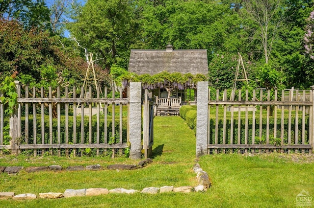 view of gate with a yard