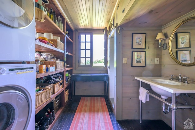 pantry featuring stacked washer / drying machine and sink