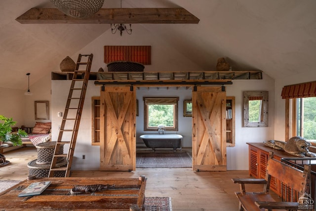 interior space featuring wood-type flooring, lofted ceiling with beams, an inviting chandelier, and a healthy amount of sunlight