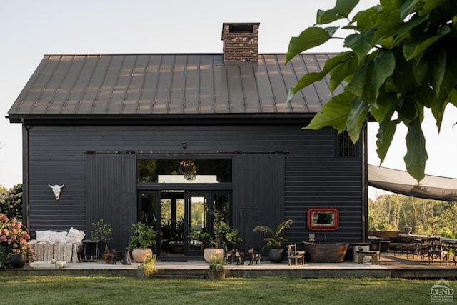 back of property featuring a lawn and a storage unit