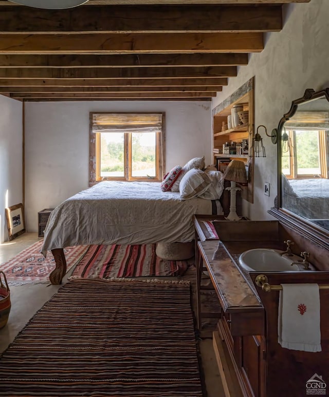 bedroom with beam ceiling and multiple windows