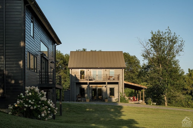 back of property featuring a lawn and a balcony