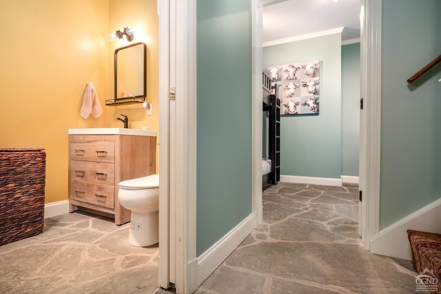 bathroom with crown molding, vanity, and toilet