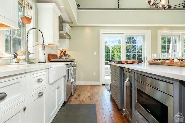 kitchen featuring decorative backsplash, appliances with stainless steel finishes, dark hardwood / wood-style flooring, pendant lighting, and white cabinets