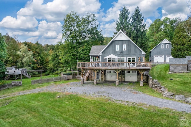 back of house featuring a yard, a garage, and a deck