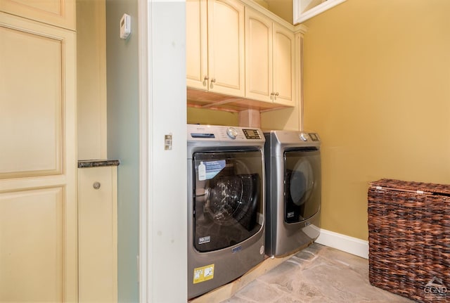 clothes washing area featuring cabinets and independent washer and dryer