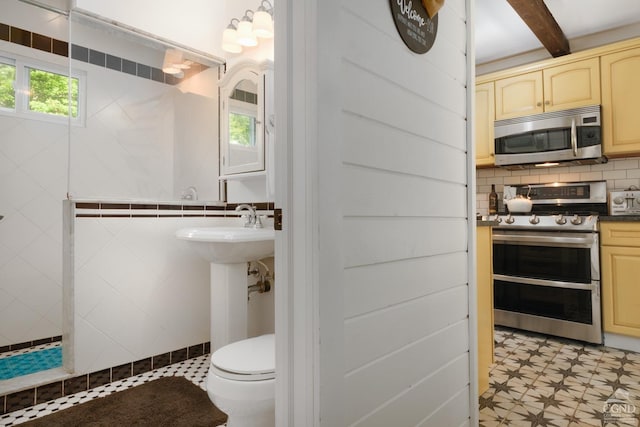 bathroom featuring backsplash, sink, beamed ceiling, and toilet