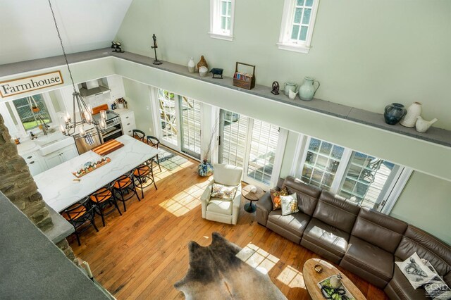 living room with a chandelier, wood-type flooring, and a high ceiling