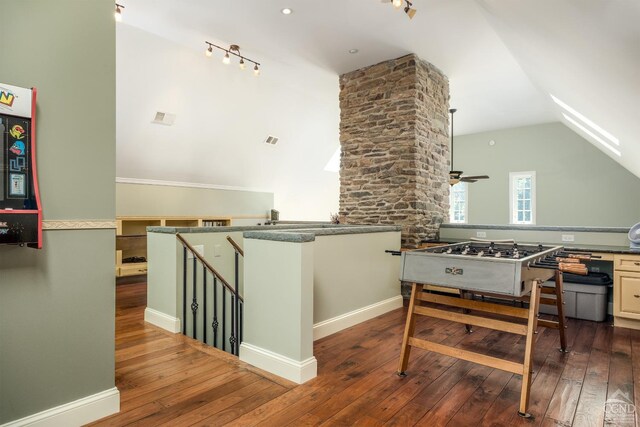 kitchen with kitchen peninsula, stainless steel gas cooktop, ceiling fan, hardwood / wood-style flooring, and lofted ceiling