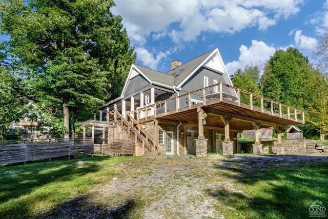 rear view of house with a lawn and a wooden deck