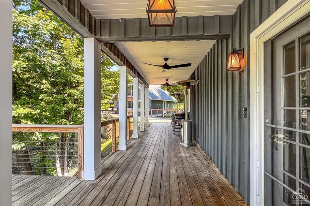 wooden deck with a porch and ceiling fan