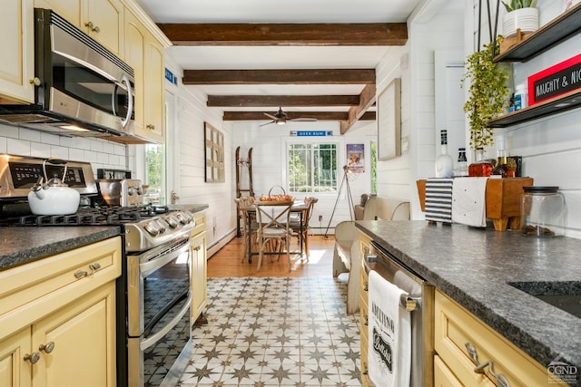 kitchen with beamed ceiling, ceiling fan, stainless steel appliances, and tasteful backsplash