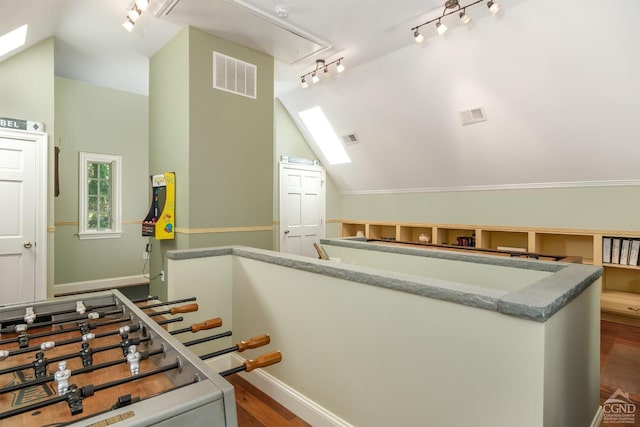 stairway with hardwood / wood-style flooring, lofted ceiling, and rail lighting