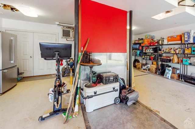 interior space with an AC wall unit and stainless steel refrigerator