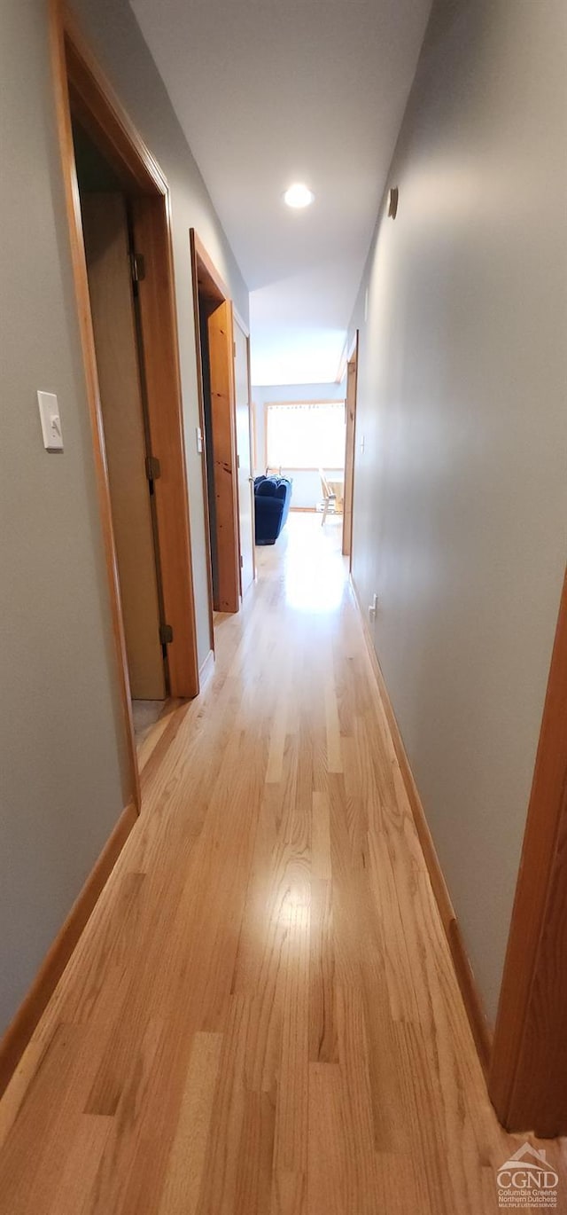 hallway featuring baseboards and light wood-style floors