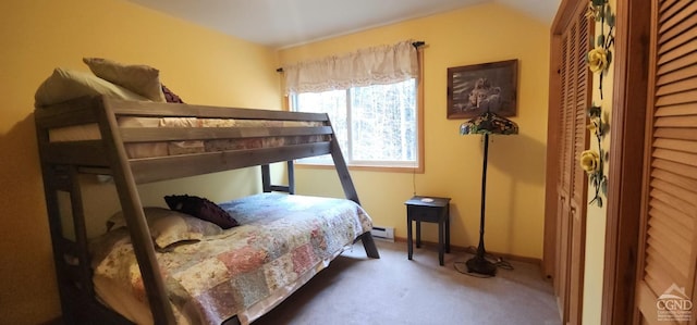 bedroom featuring baseboards, a baseboard heating unit, and carpet