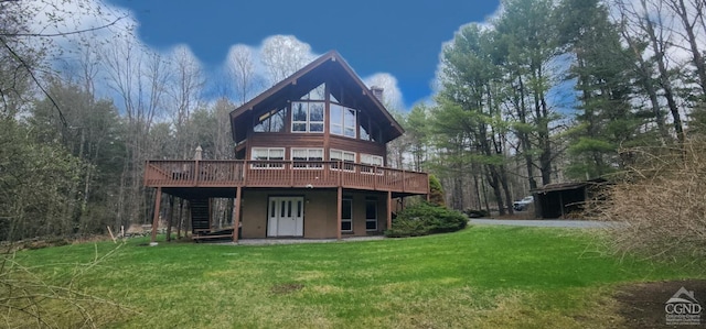 rear view of property featuring a lawn, stairs, and a wooden deck