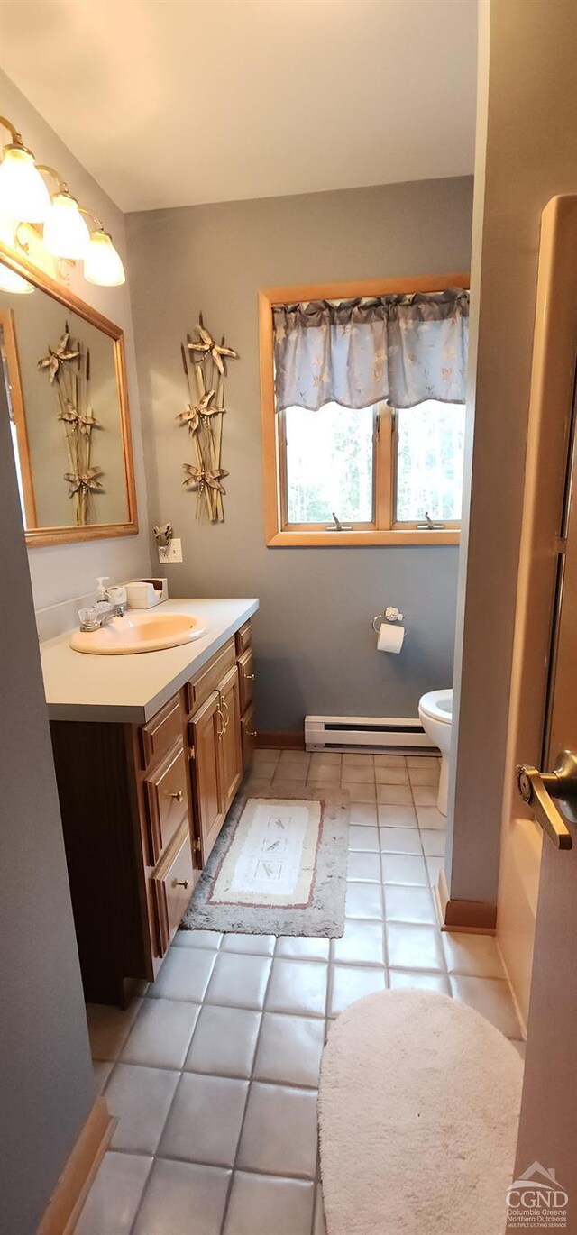bathroom featuring tile patterned floors, toilet, vanity, and a baseboard radiator