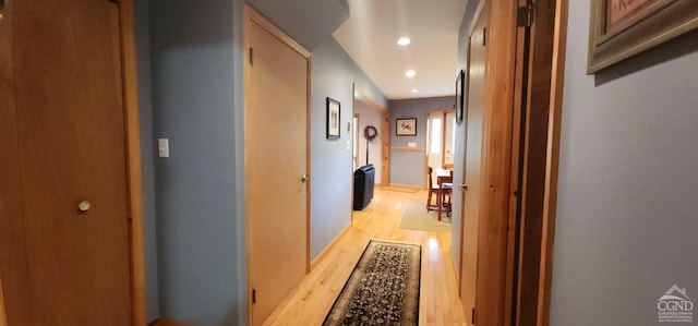 corridor with baseboards, recessed lighting, and light wood-style flooring