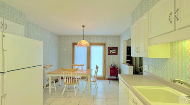 kitchen featuring hanging light fixtures, white cabinetry, sink, and white appliances