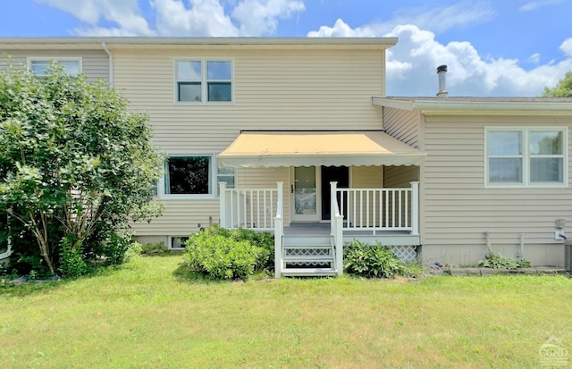 rear view of house with a wooden deck and a yard