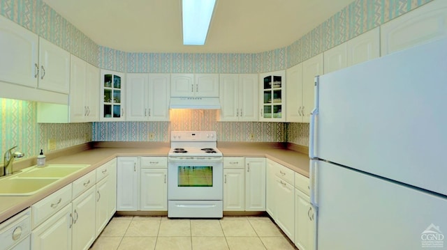 kitchen featuring light tile patterned flooring, sink, white cabinetry, white appliances, and range hood