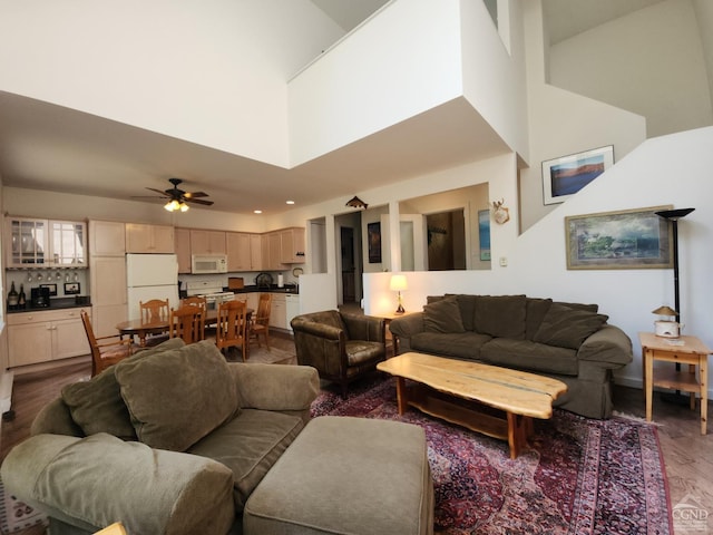 living room featuring ceiling fan, dark hardwood / wood-style flooring, and a high ceiling