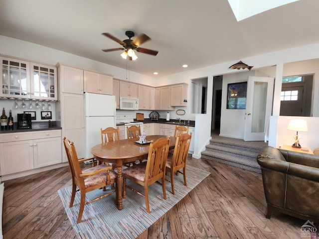 dining room with a skylight, ceiling fan, sink, and hardwood / wood-style flooring