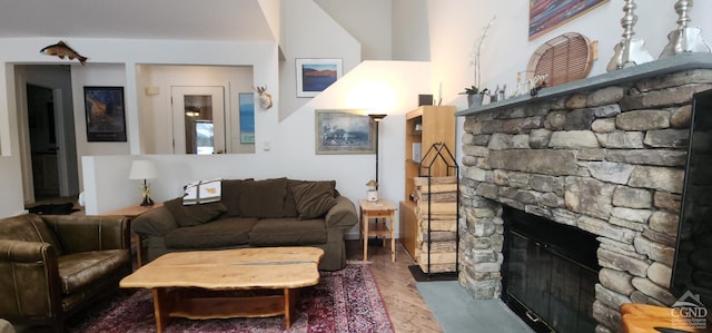 living room with wood-type flooring and a stone fireplace