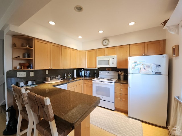 kitchen with sink, kitchen peninsula, white appliances, decorative backsplash, and light wood-type flooring