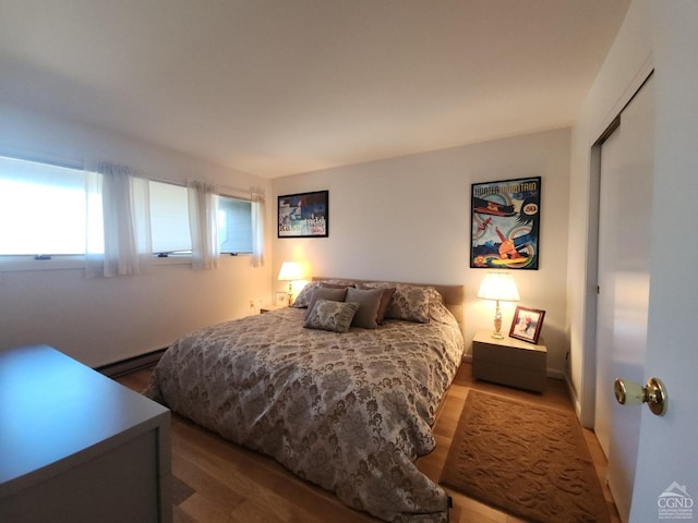 bedroom with hardwood / wood-style flooring and a baseboard radiator