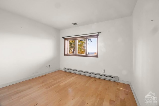 spare room featuring hardwood / wood-style floors and baseboard heating