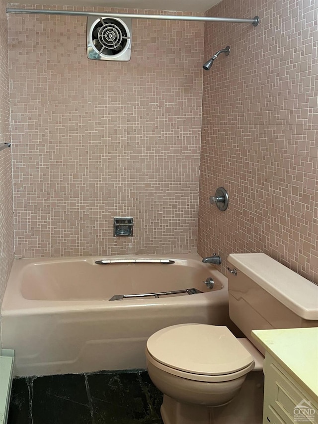 full bathroom with vanity, toilet, tile walls, and tiled shower / bath combo