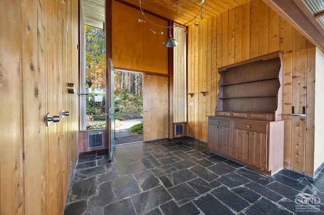 interior space with plenty of natural light, wood walls, wood ceiling, and heating unit