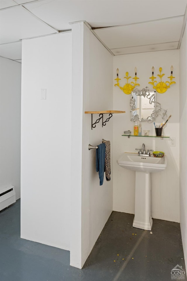 bathroom with sink, concrete floors, and a baseboard radiator