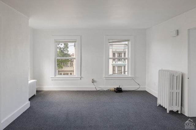 spare room with dark colored carpet and radiator