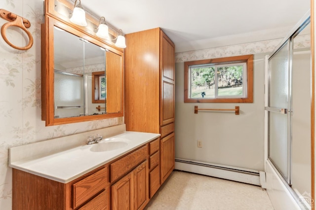 bathroom with vanity, enclosed tub / shower combo, and a baseboard heating unit