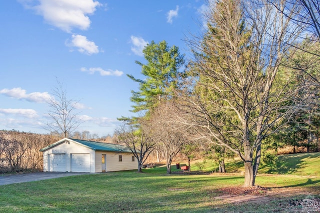 view of yard featuring a garage and an outbuilding