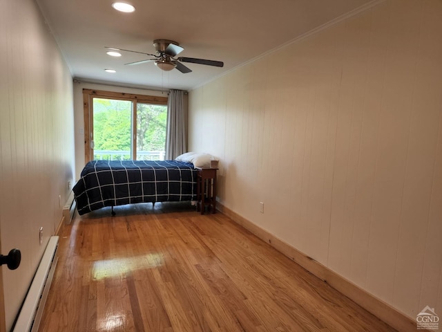 unfurnished bedroom with light wood-type flooring, crown molding, ceiling fan, and a baseboard heating unit