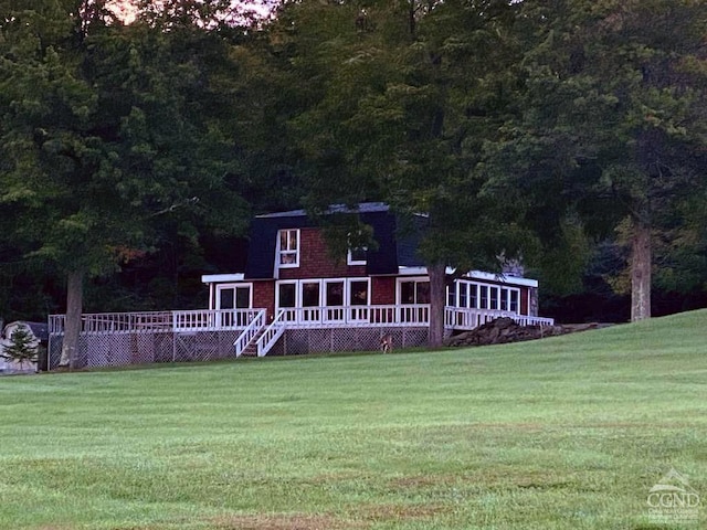 view of front of house with a deck and a front yard