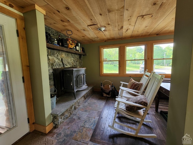 living room featuring a wood stove and wooden ceiling