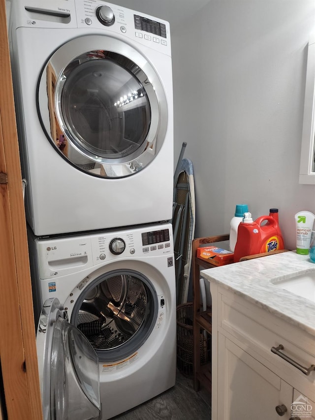 washroom with cabinets and stacked washer and dryer