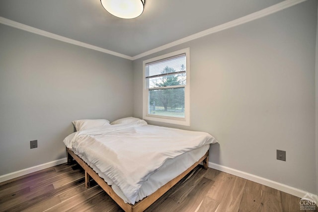 bedroom with dark hardwood / wood-style flooring and ornamental molding