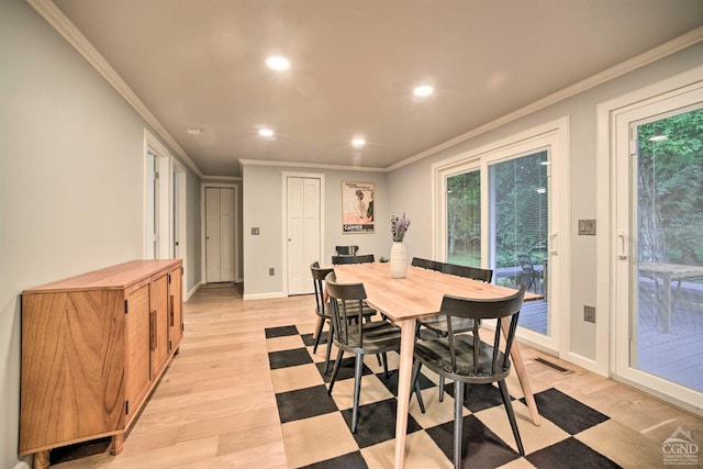 dining area with light hardwood / wood-style flooring, a wealth of natural light, and crown molding