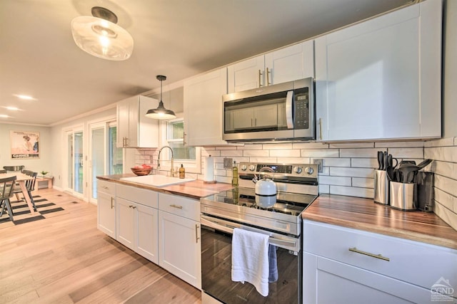 kitchen featuring appliances with stainless steel finishes, white cabinetry, and sink