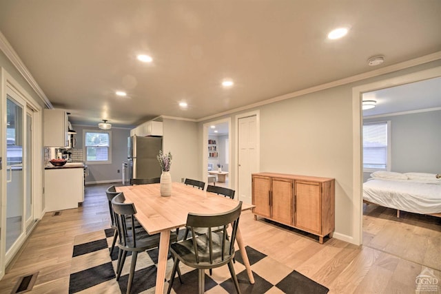 dining room with light hardwood / wood-style flooring and ornamental molding