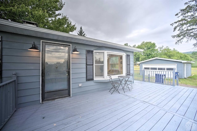 wooden terrace featuring a garage and an outdoor structure